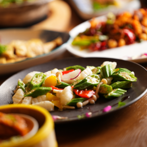 Okra and seafood stir-fry dish served on a dark plate at a restaurant.