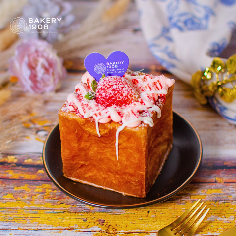 Bakery 1908 honey toast with strawberry and pink cream on a black plate.